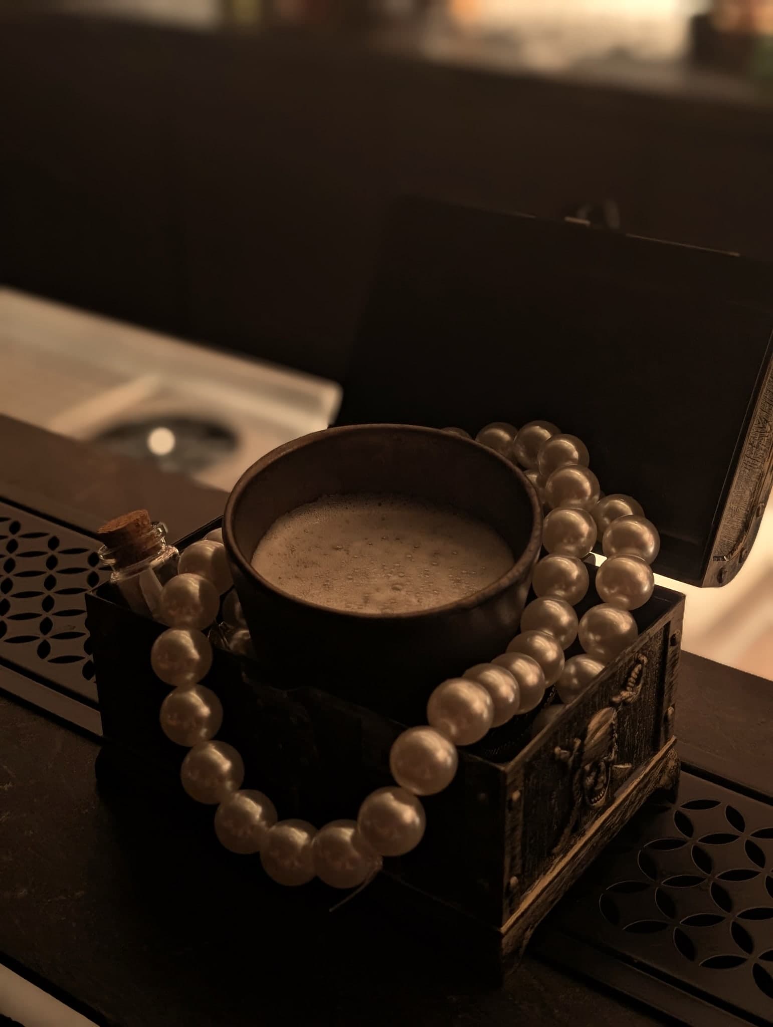 Pirate Radio at Horatio — a wooden cup of creamy banana-rum staged on a treasure chest of pearls