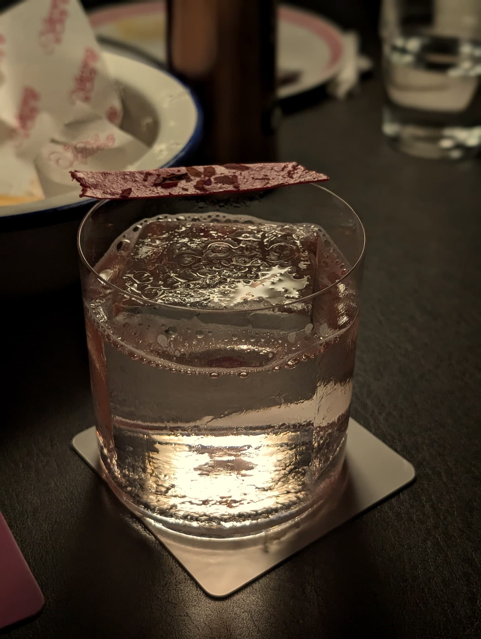 Roses & Lychee at Nutmeg & Clove — clarified-milk cocktail with a rose-petal crisp garnish