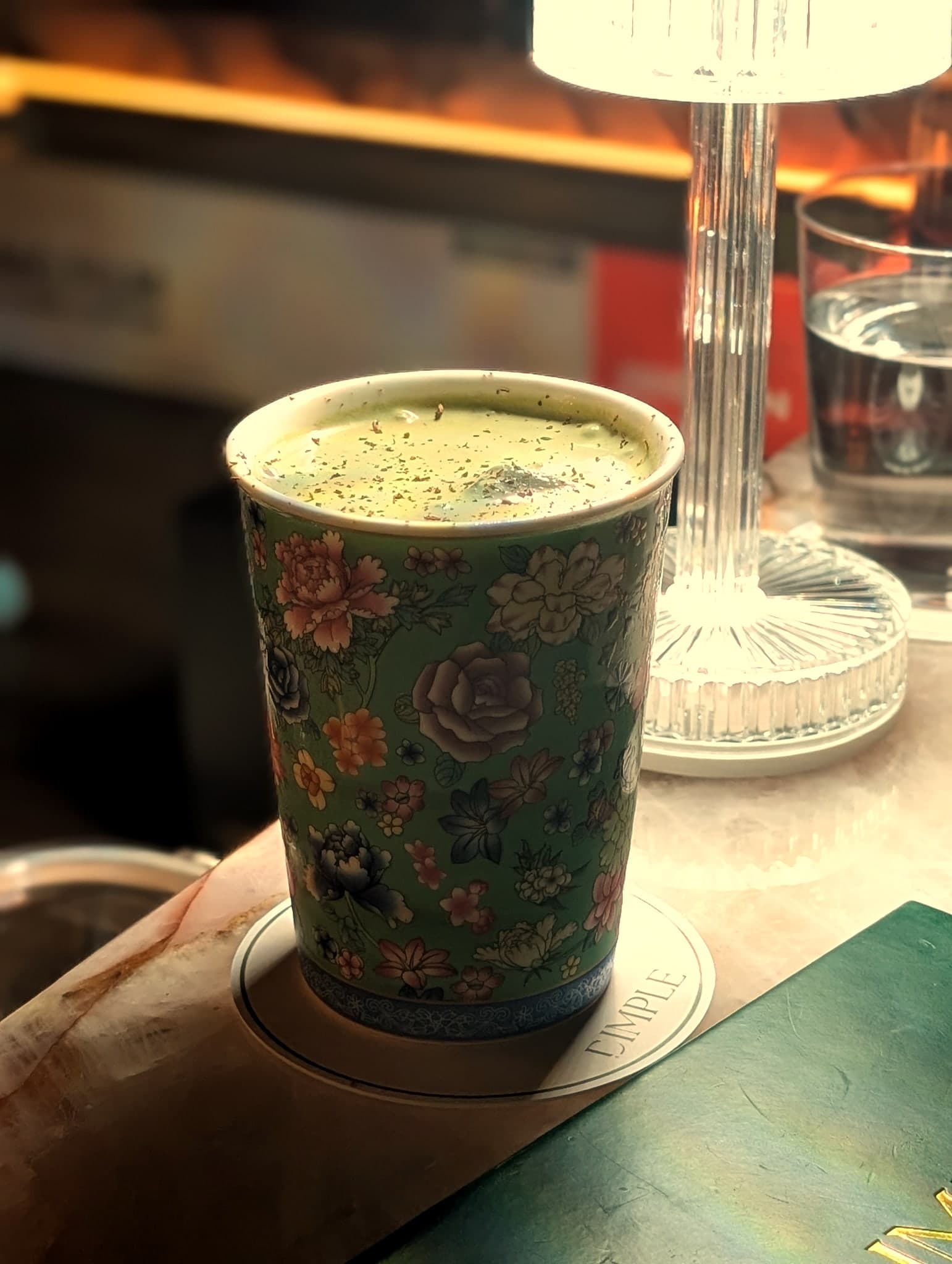 Cacao at Dimple — matcha-foamed pour in a hand-painted floral teacup