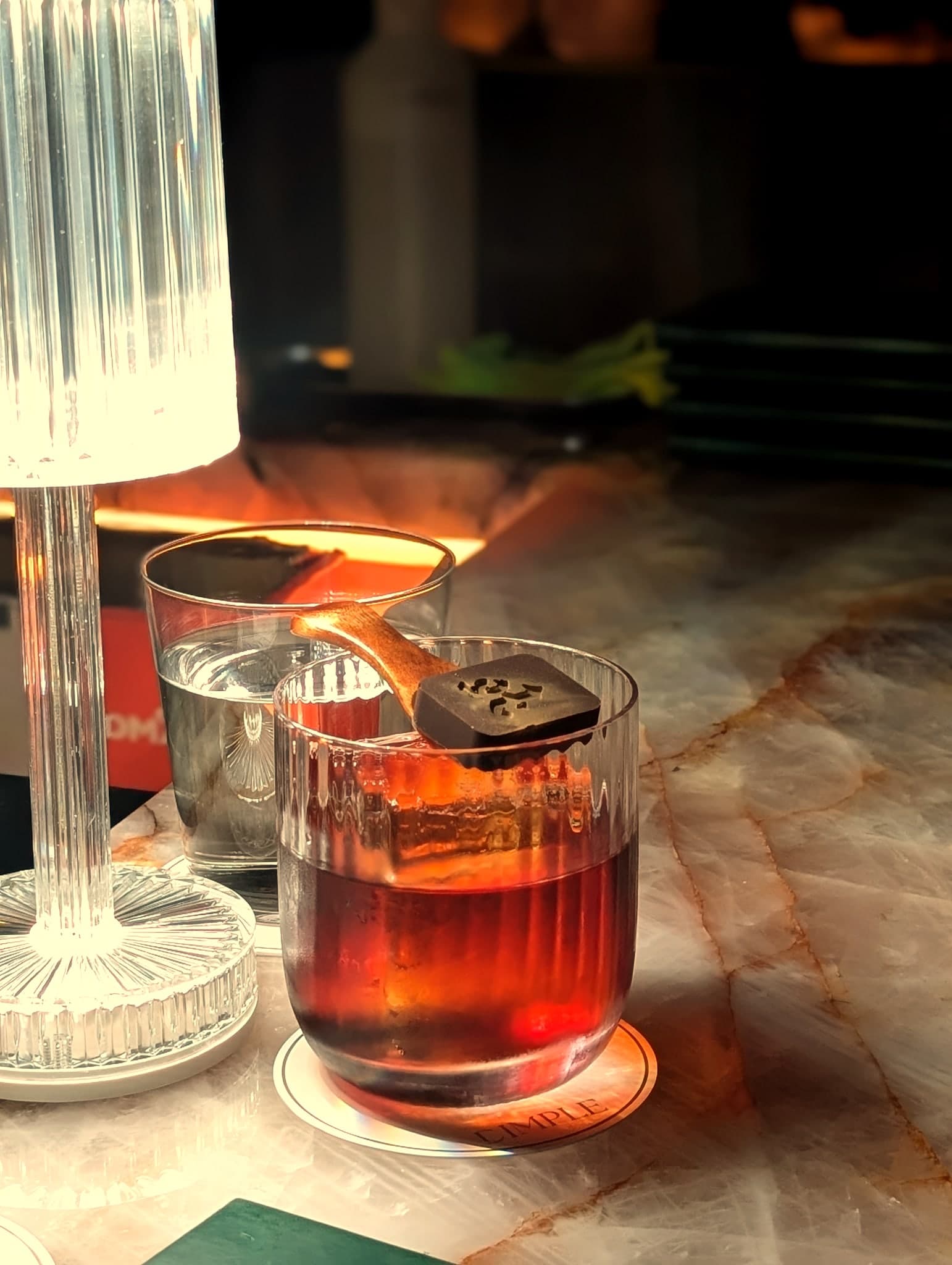 Five Flower Tea at Dimple — deep ruby rocks pour bridged with a chocolate-stamped tea agar
