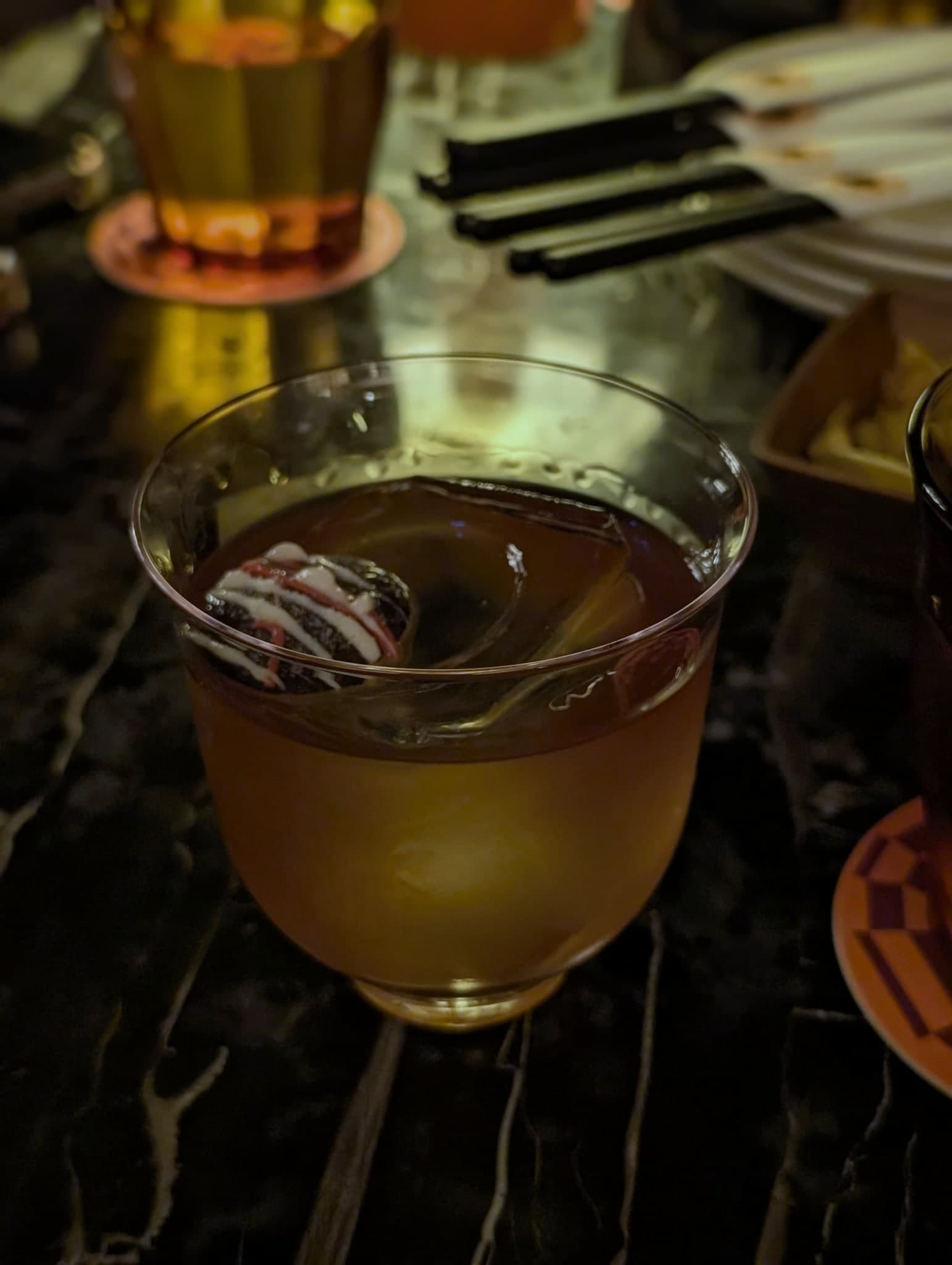 Aoyama Godfather at Pop City — amber stirred drink with a chocolate-coin garnish